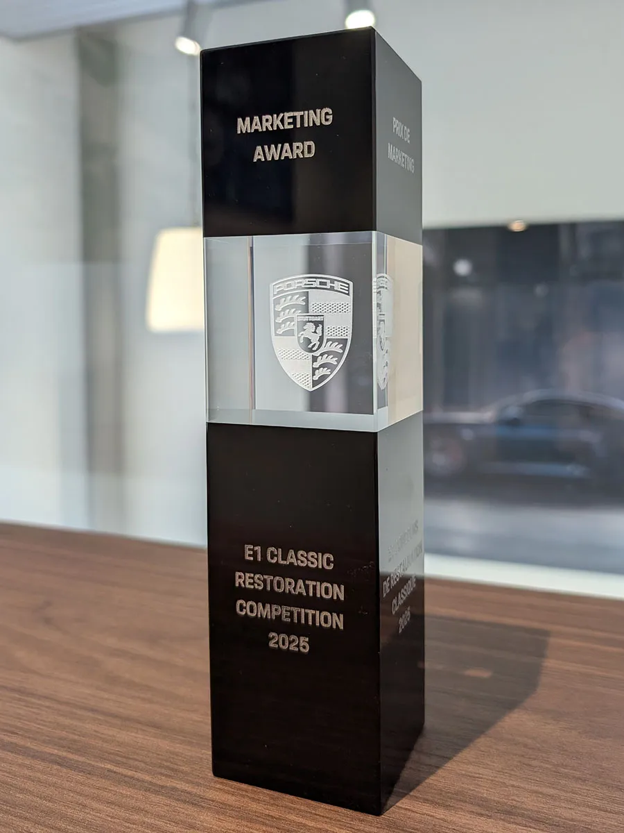 Trophée du Marketing Award 2025, Porsche Classic Restoration Competition, posé sur un bureau en bois.